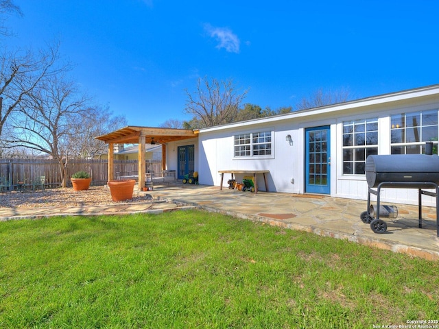 back of property with a patio area, a lawn, and fence