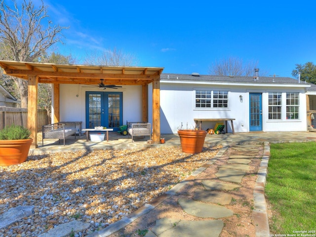 back of house with ceiling fan, fence, french doors, a patio area, and an outdoor living space