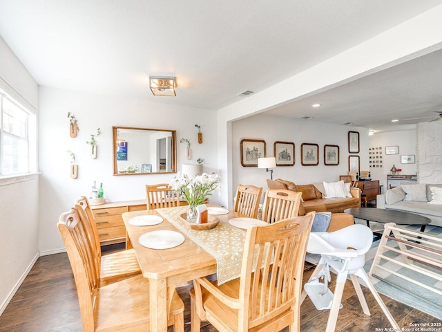 dining area with baseboards, visible vents, and dark wood finished floors