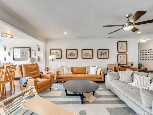 living area featuring ceiling fan, visible vents, a textured ceiling, and recessed lighting