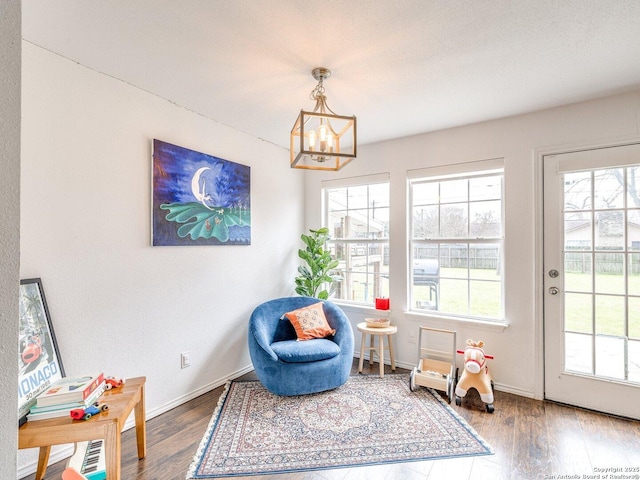 sitting room featuring dark wood-type flooring and a wealth of natural light