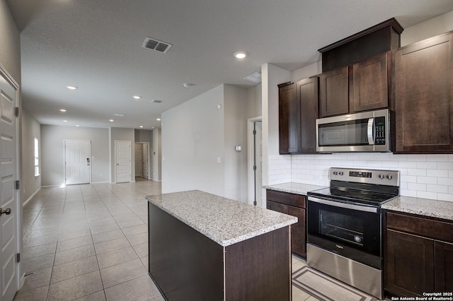 kitchen with visible vents, a kitchen island, appliances with stainless steel finishes, backsplash, and recessed lighting