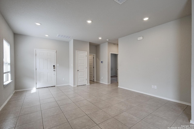 unfurnished room featuring visible vents, baseboards, light tile patterned flooring, a textured ceiling, and recessed lighting