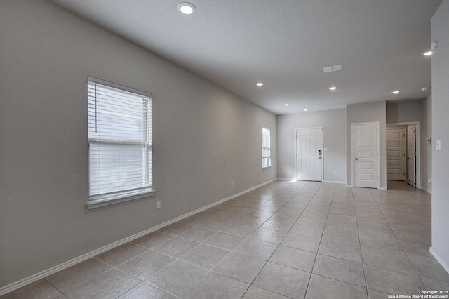 unfurnished room with light tile patterned floors, visible vents, baseboards, and recessed lighting