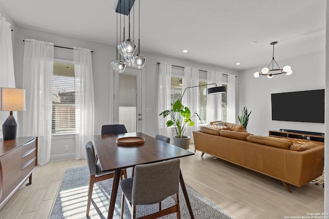 dining area with a chandelier, recessed lighting, light wood-style flooring, and baseboards