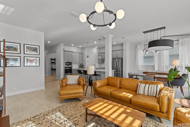 living room with recessed lighting, ornate columns, visible vents, light wood-type flooring, and baseboards