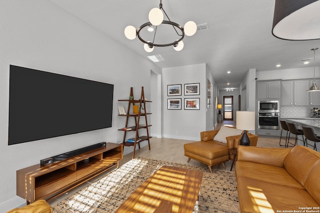 living room featuring a notable chandelier, recessed lighting, visible vents, baseboards, and light wood-type flooring