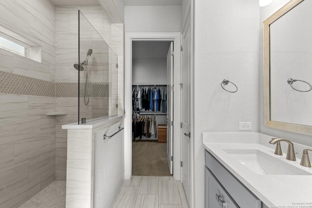 bathroom with vanity, a walk in closet, and a walk in shower