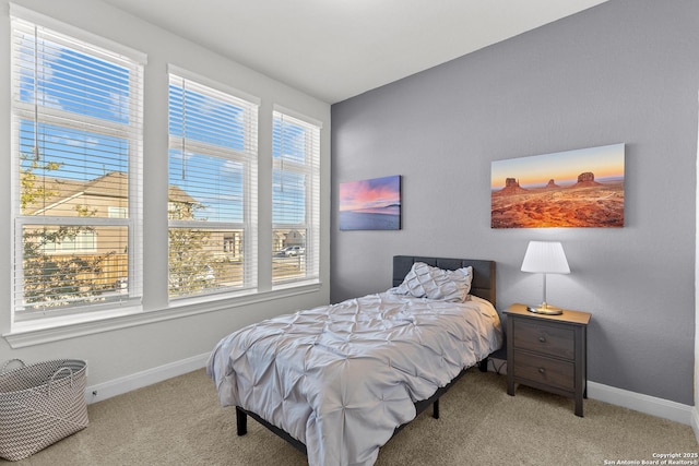 bedroom featuring baseboards and light colored carpet