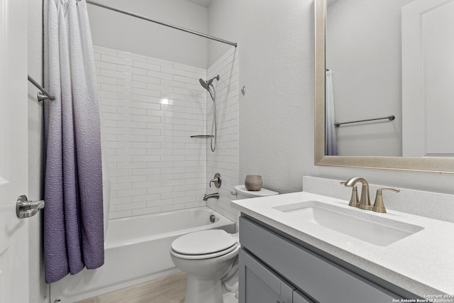 bathroom with a textured wall, toilet, wood finished floors, shower / tub combo with curtain, and vanity