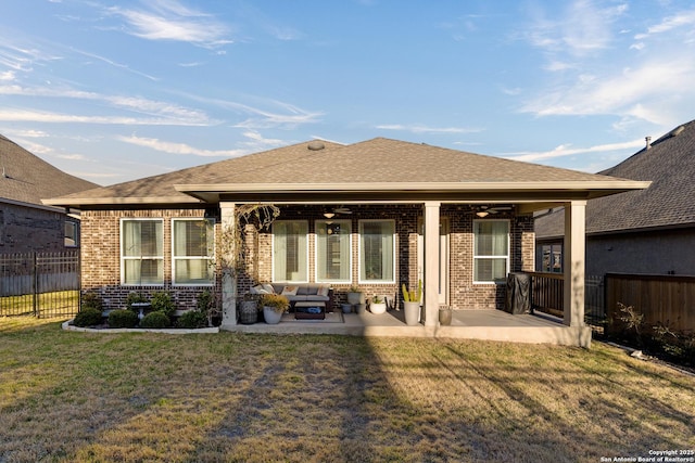 back of house featuring a yard, a patio, brick siding, and fence