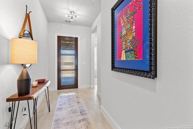 entryway featuring wood tiled floor, visible vents, and baseboards