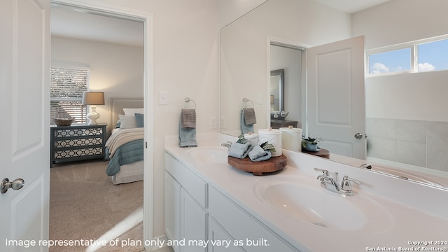 ensuite bathroom featuring a sink, double vanity, plenty of natural light, and ensuite bath