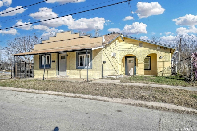 view of front facade featuring stairs, brick siding, and covered porch