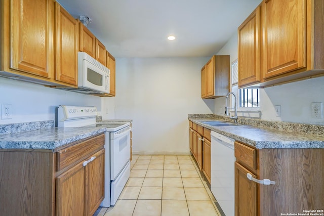 kitchen featuring white appliances, light tile patterned floors, brown cabinetry, a sink, and recessed lighting