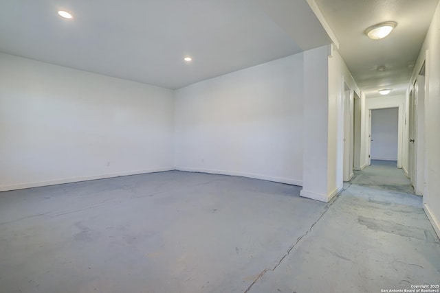 empty room with concrete floors, recessed lighting, and baseboards