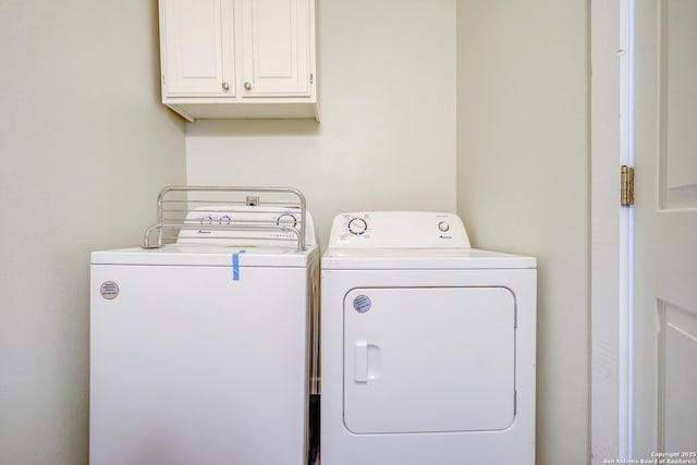 washroom featuring cabinet space and washing machine and clothes dryer