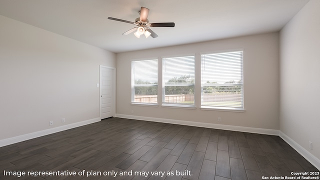 unfurnished room featuring dark wood-style flooring, a ceiling fan, and baseboards