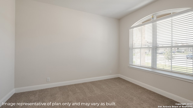 spare room featuring carpet floors and baseboards