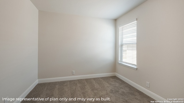 carpeted empty room with baseboards