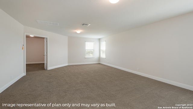 spare room with carpet, visible vents, and baseboards