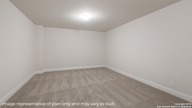 empty room with baseboards, a textured ceiling, and light colored carpet