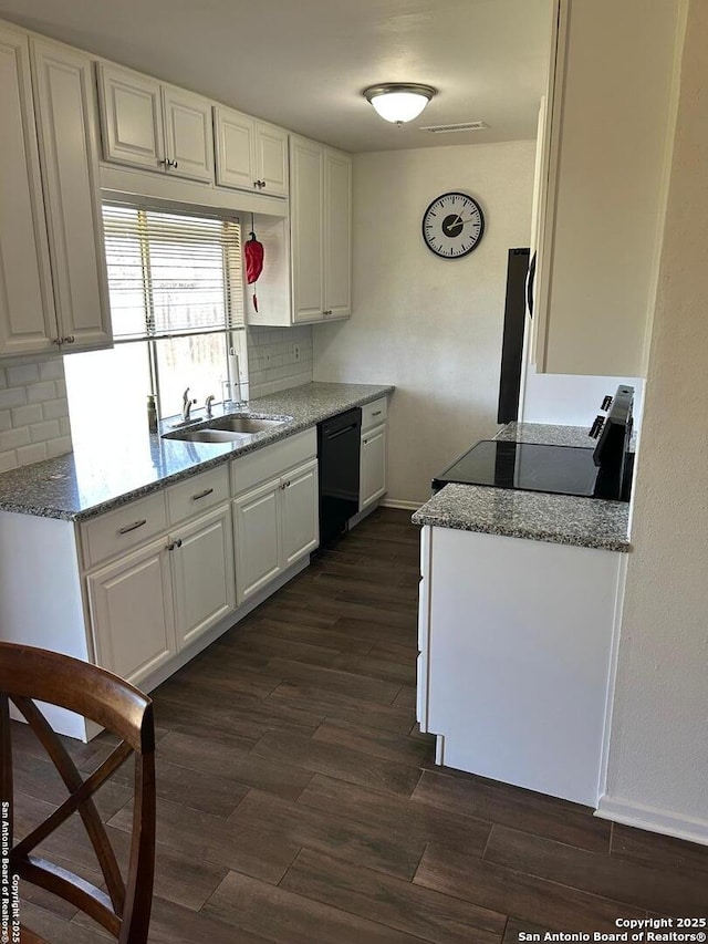 kitchen featuring black dishwasher, tasteful backsplash, dark wood-style flooring, and white cabinetry