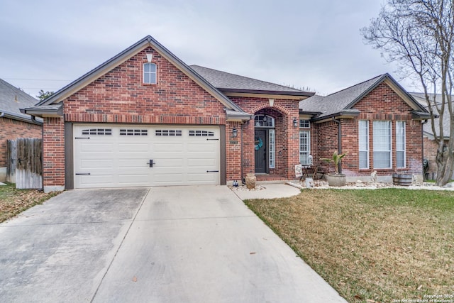 view of front of property with a garage, a front yard, concrete driveway, and brick siding