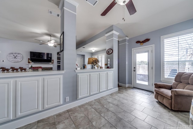 interior space with open floor plan, a wealth of natural light, visible vents, and decorative columns