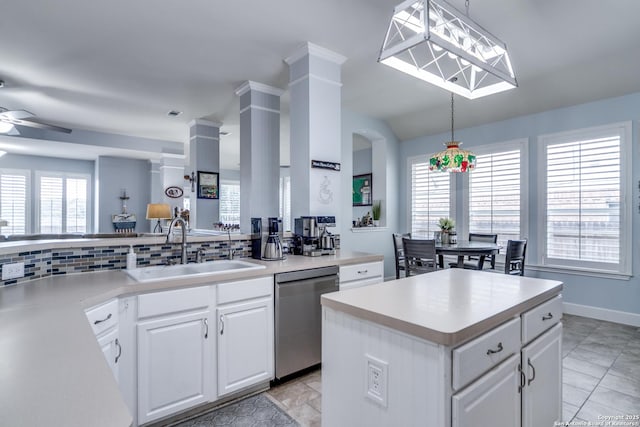 kitchen with a sink, white cabinets, stainless steel dishwasher, and a center island