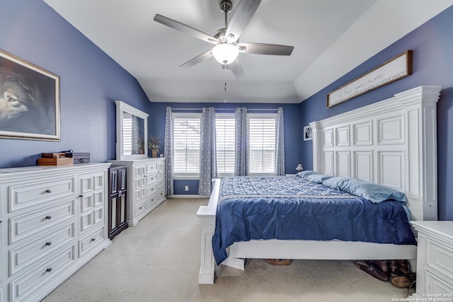 bedroom with a ceiling fan, light colored carpet, vaulted ceiling, and baseboards