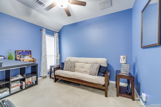 sitting room with lofted ceiling, visible vents, and light carpet