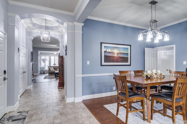 dining area featuring arched walkways, ornate columns, baseboards, and crown molding