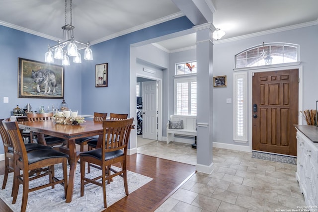 dining area with baseboards, ornamental molding, and ornate columns