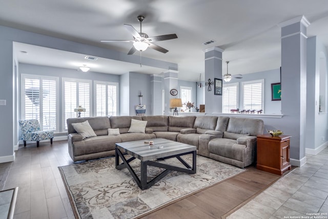 living area with wood finished floors, visible vents, and a ceiling fan