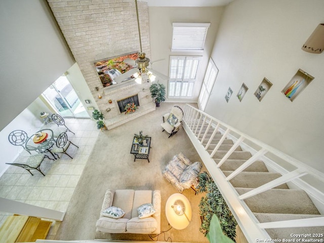 living room featuring stairs, a high ceiling, and ceiling fan