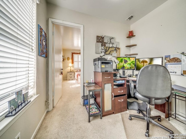 office space featuring light colored carpet, visible vents, and baseboards