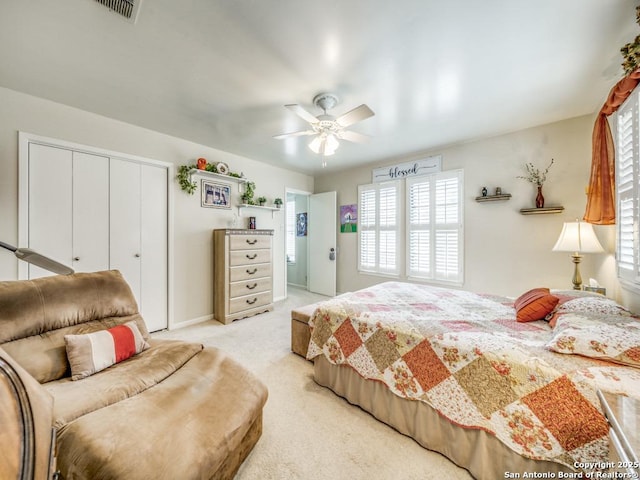 bedroom featuring a closet, light carpet, visible vents, and multiple windows