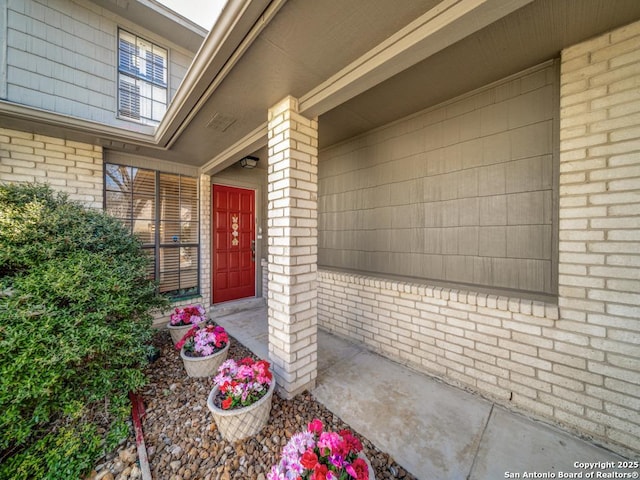 view of exterior entry featuring brick siding