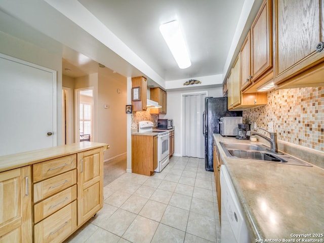 kitchen with white appliances, decorative backsplash, light countertops, a sink, and light tile patterned flooring