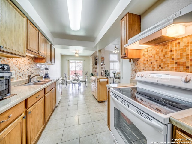 kitchen with white appliances, light countertops, a sink, and exhaust hood