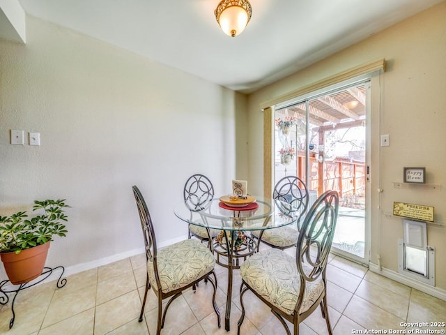 dining space with light tile patterned floors and baseboards