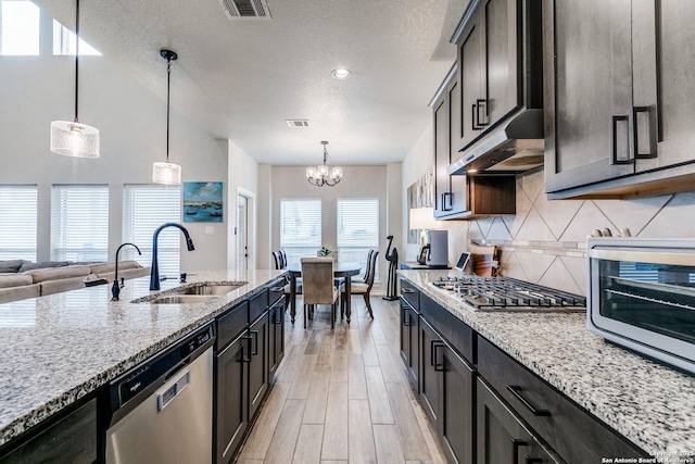 kitchen featuring stainless steel appliances, decorative light fixtures, light stone countertops, and under cabinet range hood