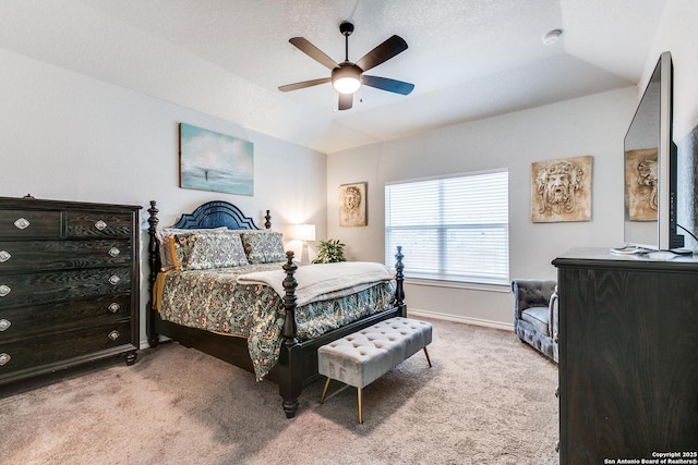 bedroom with a ceiling fan, light carpet, vaulted ceiling, a textured ceiling, and baseboards