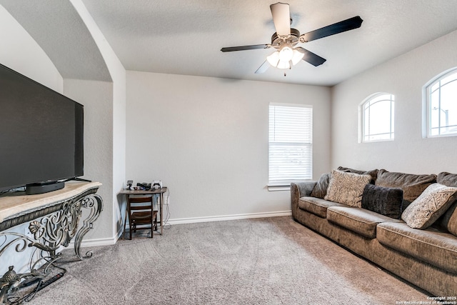 living area featuring ceiling fan, carpet floors, a textured ceiling, and baseboards