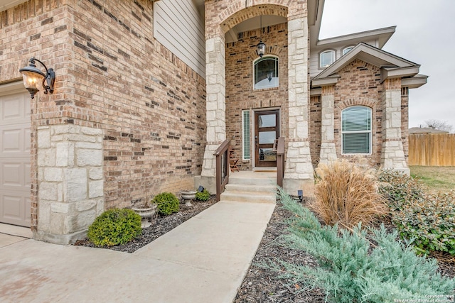 property entrance featuring brick siding and fence