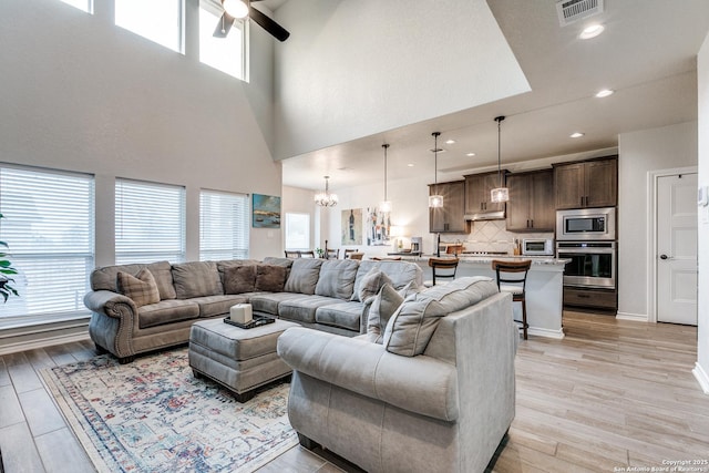 living room featuring light wood finished floors, visible vents, and a healthy amount of sunlight