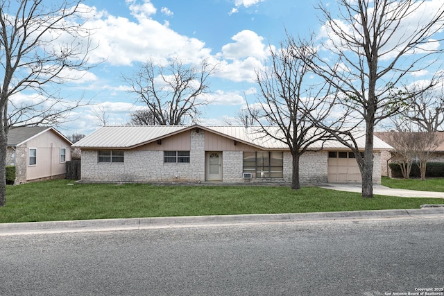 view of front of house with a garage, concrete driveway, metal roof, and a front lawn