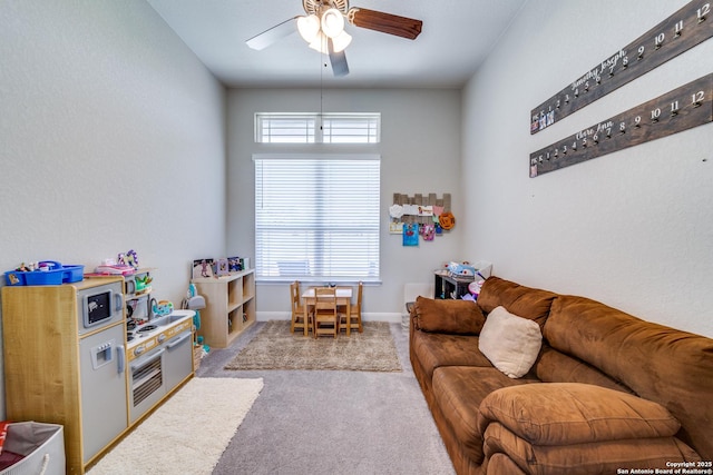 carpeted living area with baseboards and a ceiling fan