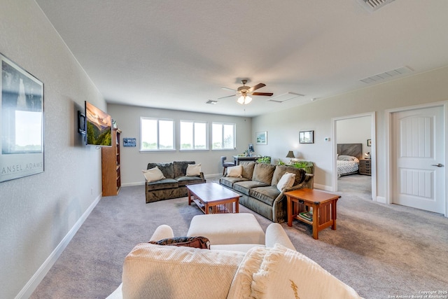 living room featuring attic access, visible vents, light carpet, and baseboards